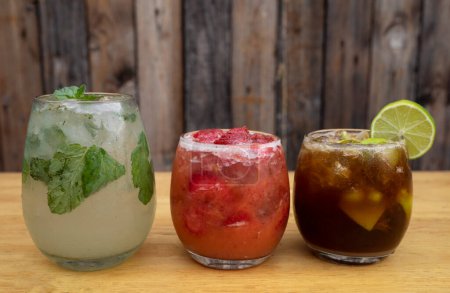 Téléchargez les photos : Vue rapprochée de trois cocktails avec un fond en bois. - en image libre de droit