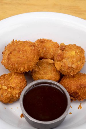 Foto de Vista de cerca de las bolas de pollo frito con una salsa picante en un tazón blanco. - Imagen libre de derechos