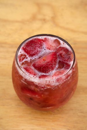 Photo for Fruit cocktail. Closeup view of a glass with a strawberry and rum drink. - Royalty Free Image