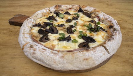 Téléchargez les photos : Pizza aux champignons. Pizza au provolone et fromage mozzarella, sauce tomate et champignons, sur la table en bois. - en image libre de droit