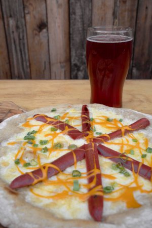 Photo for Pizza. Closeup view of mozzarella cheese pizza with cheddar cheese, green onion, smoked sausages and a glass of beer. - Royalty Free Image