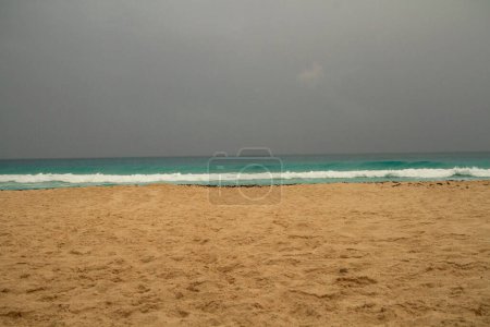 Foto de Playa caribeña. Dramática vista de la arena, la orilla, el color turquesa del agua del océano, las olas del mar y el cielo tormentoso en Cancún, México. - Imagen libre de derechos