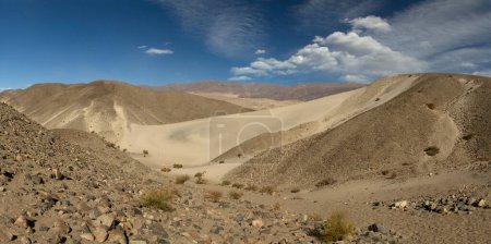 Foto de Paisaje del desierto. Vista panorámica de las hermosas dunas de arena amarilla, colinas rocosas y áridas, bajo un cielo azul veraniego. - Imagen libre de derechos