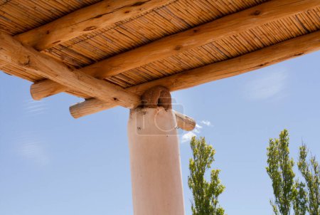 Foto de Vida en el campo. Vista de cerca del nido de aves hecho de arcilla en la columna y techo rústico de madera hecho de cañas de la casa rural. - Imagen libre de derechos
