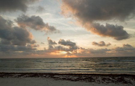 Foto de Verano. Paisaje marino del Caribe. La arena blanca, el sargazo y el mar al atardecer. Hermosos colores del atardecer en el cielo, nubes y olas del océano. - Imagen libre de derechos