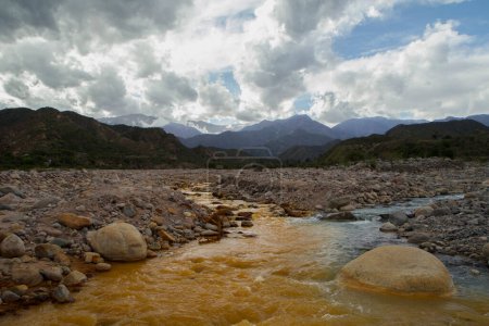 Téléchargez les photos : Géologie. Le populaire fleuve Jaune à Chilecito, La Rioja, Argentine. Vue sur le confluent jaune et bleu de la rivière, coulant le long de la vallée rocheuse dans les montagnes en une journée d'été. - en image libre de droit