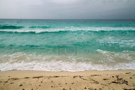 Foto de Playa caribeña vacía con agua de color turquesa, en un día tormentoso. - Imagen libre de derechos