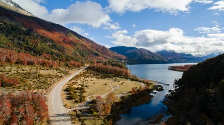 Foto de Colores de otoño. Vista aérea de la carretera además del lago y a través de las montañas y el bosque en otoño. - Imagen libre de derechos