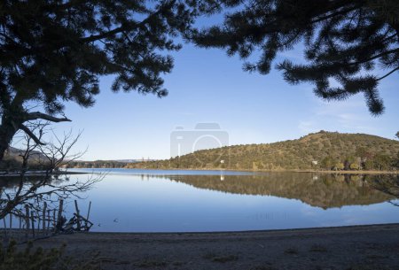 Téléchargez les photos : Belle vue sur le lac. Le rivage, les collines, la forêt et le ciel et son reflet symétrique à la surface de l'eau. - en image libre de droit