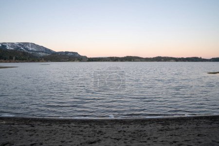 Téléchargez les photos : Le lac, la rive et les montagnes à l'horizon à la tombée de la nuit. - en image libre de droit
