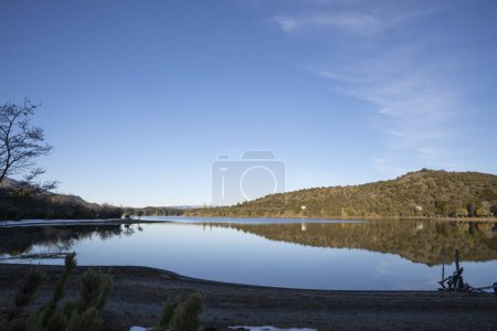 Téléchargez les photos : Vue sur le lac paisible par une journée ensoleillée d'été. La forêt, les montagnes et la réflexion du ciel bleu à la surface de l'eau. - en image libre de droit