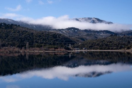 Téléchargez les photos : Symétrie dans la nature. Paysage alpin. Vue magique sur les montagnes et la forêt reflétée sur l'eau du lac par une journée d'été ensoleillée. - en image libre de droit