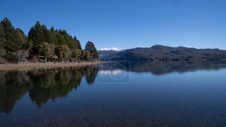 Photo for View of volcano Batea Mahuida, Andes mountains, forest and Alumine lake in Villa Pehuenia, Patagonia Argentina. Beautiful landscape and blue sky reflection in the glacier water. - Royalty Free Image