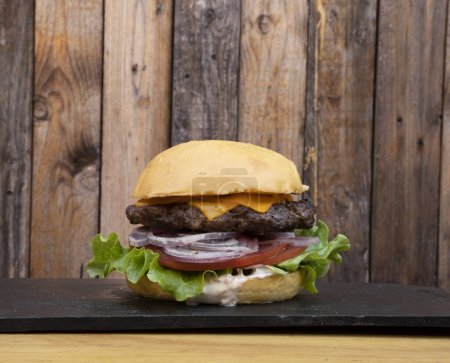 Téléchargez les photos : Délicieux cheeseburger sur fond en bois - en image libre de droit