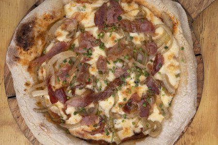 Foto de Vista superior de una pizza hecha con salsa de tomate, queso mozzarella, tocino crujiente y cebolla, con fondo de madera. - Imagen libre de derechos