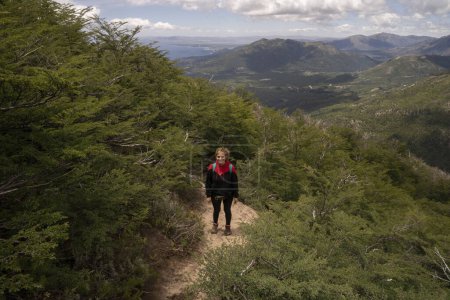 Foto de Senderismo por el sendero de montaña. Retrato de una joven trekking a lo largo del sendero a través de la colina y el bosque. - Imagen libre de derechos