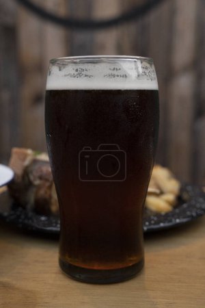 Téléchargez les photos : Brew. Vue rapprochée d'une bière ambre sur la table en bois. - en image libre de droit