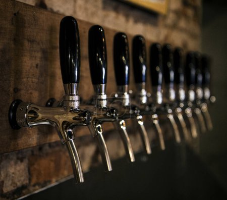 Photo for Drinks. Classic metal craft beer taps in the bar. - Royalty Free Image