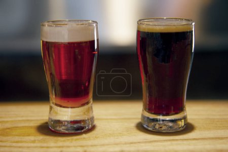 Foto de Muestras de cerveza. Vista de cerca de un negro fuerte y vasos de cerveza ámbar ale. - Imagen libre de derechos