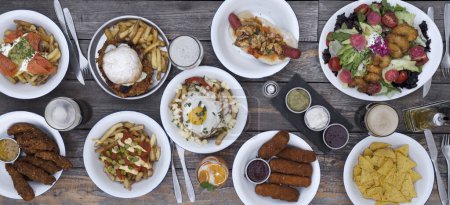 Photo for Feast. Panorama top view of delicious food laid out on the restaurant wooden table. - Royalty Free Image