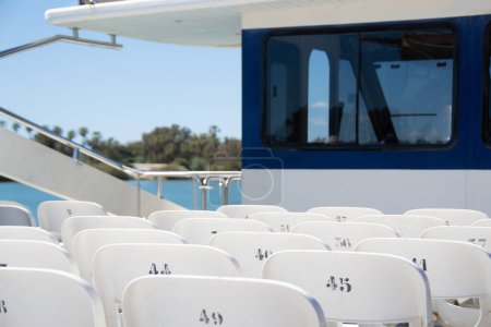Unbesetzte, nummerierte weiße Sitze einer Touristenkreuzfahrt im Ebro-Delta, Spanien.