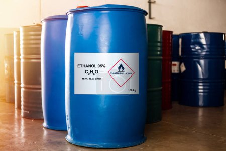 Foto de El tamaño del tambor azul 160 kg de etanol 95% con la etiqueta de líquido inflamable muestra precaución para su uso. Además, tiene un barril químico de otros disolventes a su lado. - Imagen libre de derechos