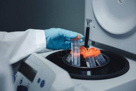 Foto de Los investigadores colocan el tubo de ensayo de extracción de ADN de Ecoli en una máquina centrífuga para separar el ADN de la solución durante la investigación de ADN. - Imagen libre de derechos
