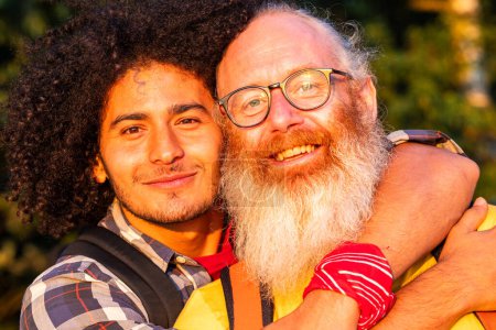 Photo for Celebrate loves diverse beauty with this heartwarming image. A gay couple, differing in age and race, share a tender embrace amidst natures serene beauty. Their smiles, bright and unfeigned, radiate - Royalty Free Image