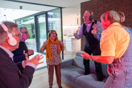 This lively image depicts a group of seniors fully immersed in the joy of a silent disco at home. They are each wearing wireless headphones and are engrossed in the music only they can hear, as