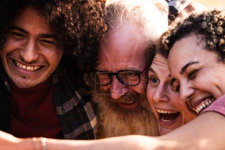Photo for This image captures an intimate and heartwarming moment among a diverse group of friends. On the left, a young Middle-Eastern man with curly hair and a beard shares a laugh, his eyes crinkling with - Royalty Free Image