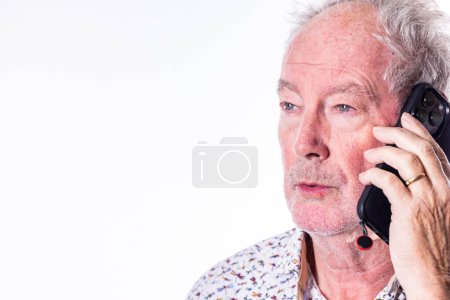 This portrait showcases an elderly gentleman deeply engrossed in a phone conversation. His expression is one of focused attention, perhaps listening intently or pondering a response. The classic