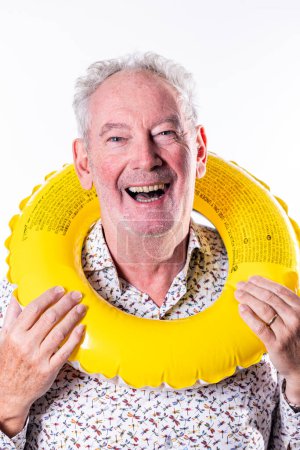 The photograph captures a senior mans infectious joy as he holds up a bright yellow swim ring, ready for some fun in the water. His wide smile and sparkling eyes exude excitement and a zest for life