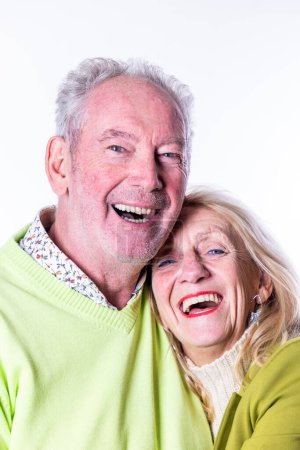 This delightful image captures the radiant joy of a senior couple sharing a close and happy embrace. Their faces are lit up with wide, genuine smiles, reflecting a deep and abiding happiness. The man