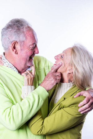 Photo for This heartwarming image captures a moment of playful affection between a senior man and woman. The man is seen teasingly pointing at the womans nose, both sharing a moment of laughter and closeness - Royalty Free Image
