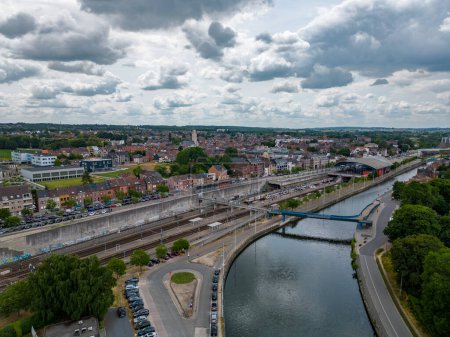 Diese Luftaufnahme von Halle zeigt die komplizierte Verbindung zwischen den Wasserstraßen der Stadt und ihrer Infrastruktur. Der fließende Fluss, gesäumt von Wegen und Grün, dient als natürliche Lebensader