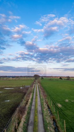 Photo for Country Road and Farmland Under a Cloud-Adorned Sky Country Road and Farmland Under a Cloud-Adorned Sky. High quality photo - Royalty Free Image