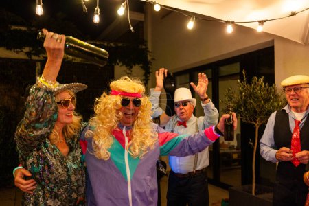A group of elderly friends exude joy during a lively costume party, complete with playful outfits and exuberant poses, under festive string lights. Elderly Friends Enjoying a Festive Costume Party