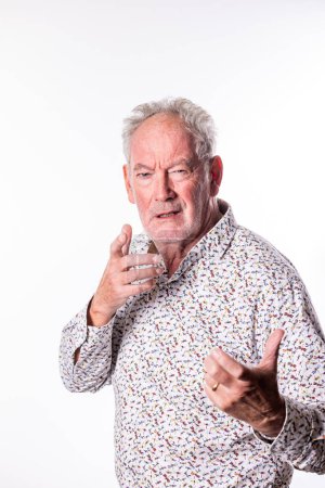 A senior man appears engaged in a conversation, captured mid-gesture with a focused expression. The intricate pattern on his shirt adds a lively touch to the image, set against a clean white