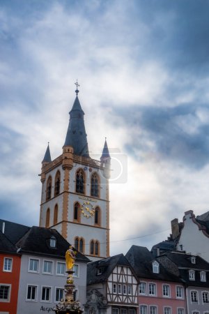 Téléchargez les photos : Trèves, Rijnland-Palts, Allemagne, 23 mars 2024, Cette image capture l'emblématique tour de la mairie de Trèves, en Allemagne, baignée de lumière du soleil qui traverse un ciel couvert. Le contraste de la - en image libre de droit