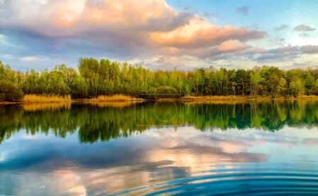 A tranquil lake surrounded by lush greenery, with vibrant water reflecting a dramatic sky a serene scene in nature