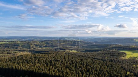 Luftaufnahme eines ruhigen Panoramas mit üppigen Wäldern, sanften Hügeln, endlosem Himmel, der eine friedliche Umgebung schafft