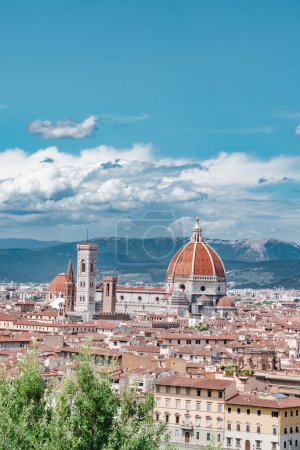 Photo for View of Florence cityscape with Santa Maria del Fiore cathedral surrounded with residential buildings and mountain in background under blue sky white clouds at Tuscany, Italy - Royalty Free Image