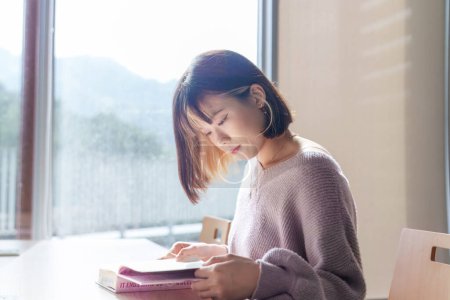Foto de Vídeo en cámara lenta de una estudiante universitaria taiwanesa de 20 años de edad que pasa tiempo en una hermosa biblioteca en una universidad en el distrito de Wenshan, Taipei City, Taiwán - Imagen libre de derechos