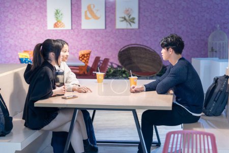 Foto de Tres estudiantes universitarios taiwaneses y asiáticos hablando en una cafetería universitaria en el distrito Da 'an, Taipei City, Taiwán - Imagen libre de derechos