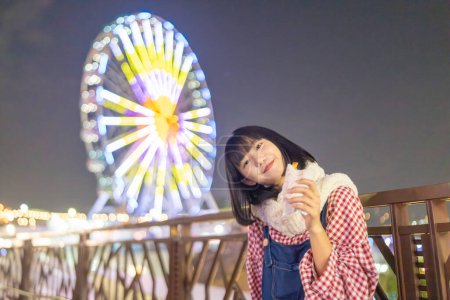 Foto de Una joven taiwanesa de unos 20 años jugando de noche en un parque de diversiones en el distrito de Shilin, Taipei City, Taiwán - Imagen libre de derechos