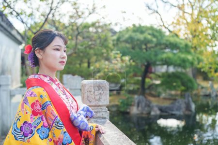 A young Japanese woman in her 20s wearing Ryuso in a Chinese garden in Naha City, Okinawa Prefecture