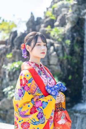 A young Japanese woman in her 20s wearing Ryuso in a Chinese garden in Naha City, Okinawa Prefecture