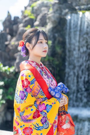 Une jeune femme japonaise dans la vingtaine portant Ryuso dans un jardin chinois à Naha City, préfecture d'Okinawa