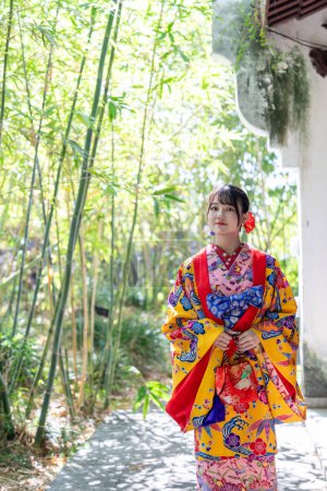 Une jeune femme japonaise dans la vingtaine portant Ryuso dans un jardin chinois à Naha City, préfecture d'Okinawa