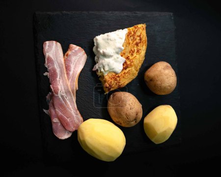 Delight in the harmonious fusion of Spanish and Italian flavors with our exquisite potato omelet drizzled with creamy carbonara sauce. Presented on a pristine white plate, surrounded by the fresh ingredients that make it unforgettable: potatoes, eggs
